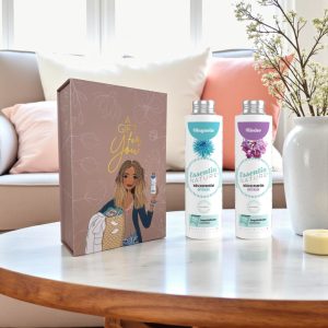 Wasgeluk cadeaupakket met twee flessen Essentia Nature wasparfum in de geuren Magnolia en Flieder op een salontafel in een stijlvol, gezellig interieur.